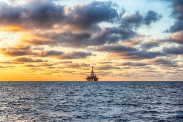 hdr de offshore jack up rig no meio do mar na hora do pôr do sol - oil pumping unit at sunset time - fotografias e filmes do acervo