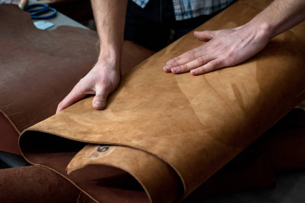 istock hands of a craftsman on leather rolls. chiaroscuro artistic, suede 1205821589