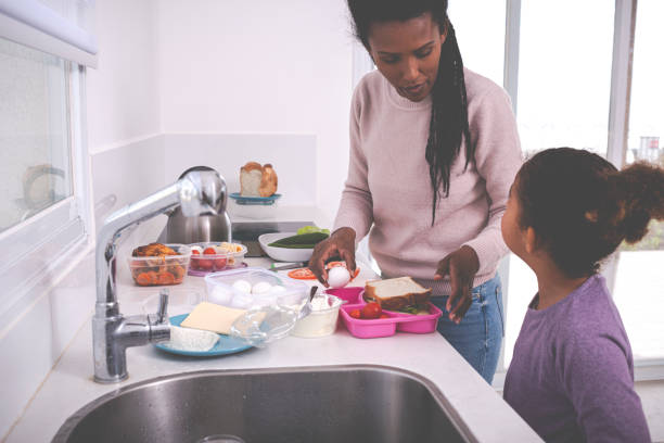 mamá e hija empacando el almuerzo. - healthy eating snack child domestic kitchen fotografías e imágenes de stock