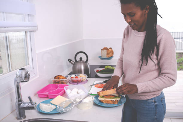 istock Woman preparing a healthy sandwich, packing lunch box. 1205824798