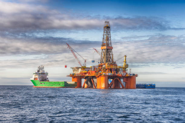 Supply vessel during operation along side with a drilling rig stock photo