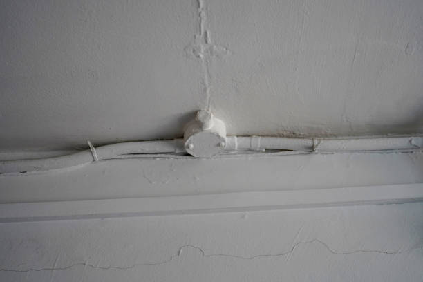 istock Old cables and pipes on a white wall 1205824995