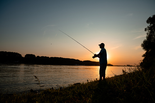 Men fishing on the river,beautiful sunset and peaceful evening