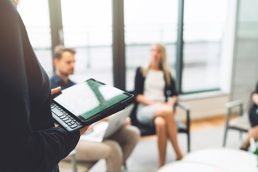 Woman holding a digital tablet during a business meeting.