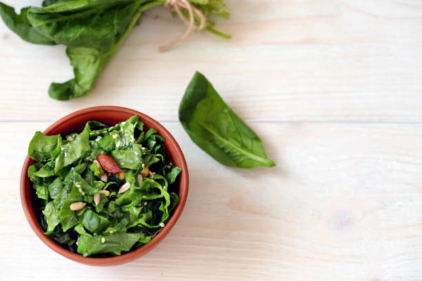 istock Vegan spinach salad on a light wooden background 1205827331