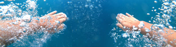 mergulhador nadando em uma água azul clara - bubble swimming pool water underwater - fotografias e filmes do acervo