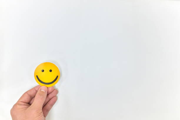 istock A hand holding a yellow smiley face on a white background. Positive feedback, happy customer and good service concepts 1205836824