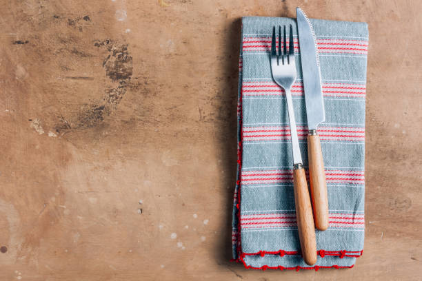 istock Table setting with white plate, fork, knife and napkins on beige rustic table. Top view. Flat lay 1205837532