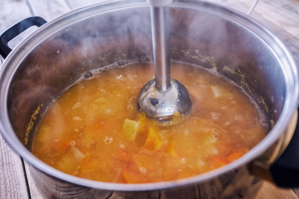 préparation de la soupe de citrouille, mélange à l’aide d’un mélangeur à bâtons - making soup photos et images de collection