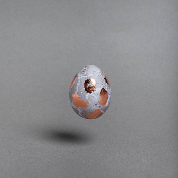 istock A golden polka dot egg hovers above the surface. Minimalistic design for postcards. 1205839371