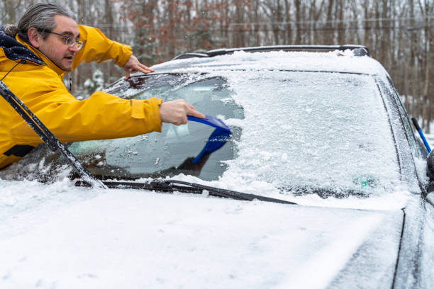 istock Man cleaning car's windshield from the snow and ice after a snowfall 1205839456