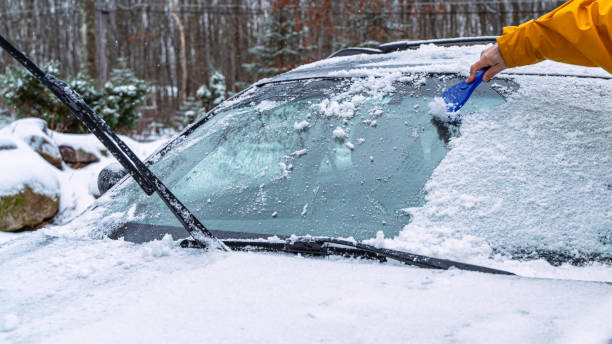 istock Man cleaning a car from the snow after a snowfall 1205839480
