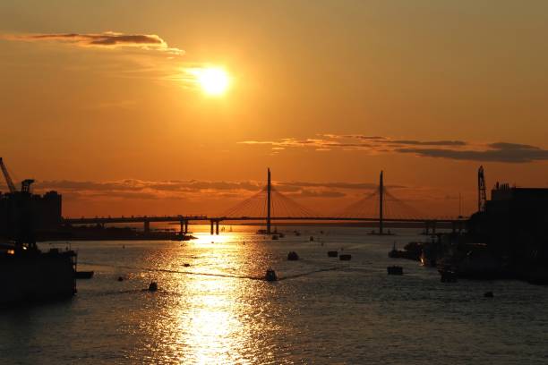 istock orange sunset over the river with a bridge and boats 1205839556