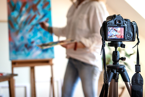 Female artist recording her video tutorial about art painting. Freelance woman sharing online her job