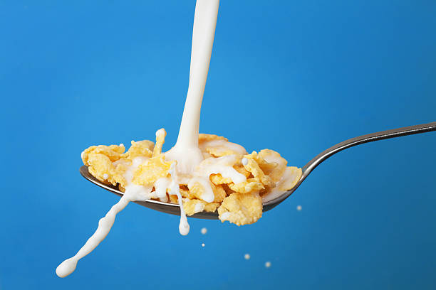 istock milk splashing into spoon with cornflakes over blue 120584227