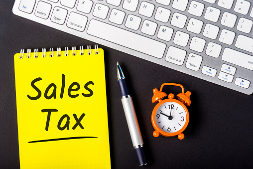 Sales Tax - from the consumer at the point of purchase or online shop. Shopping and taxation. Workplace of an accountant.