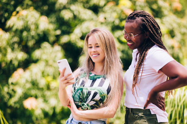 istock Two young female friends using smartphone 1205845792