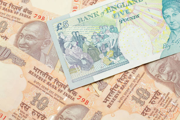 istock A UK five pound note on a background of Indian ten rupee bank notes 1205846654