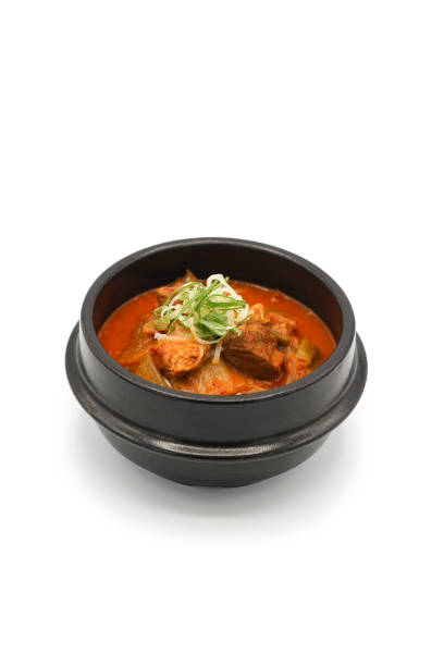 Isolated Kimchi soup in the black stone bowl in studio light on the white background.