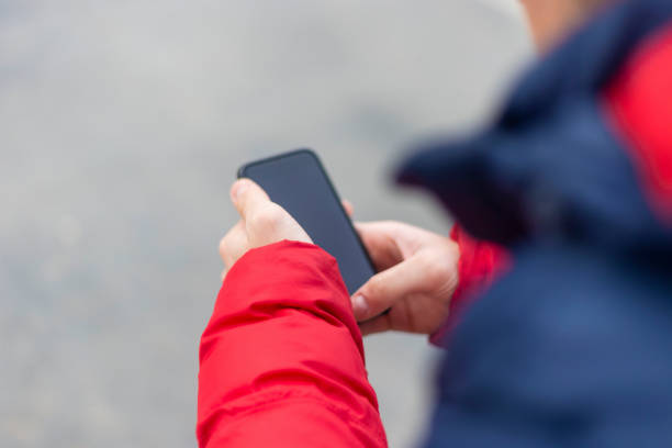 istock Young man with smartphone in hand texting outdoors in the street 1205848879