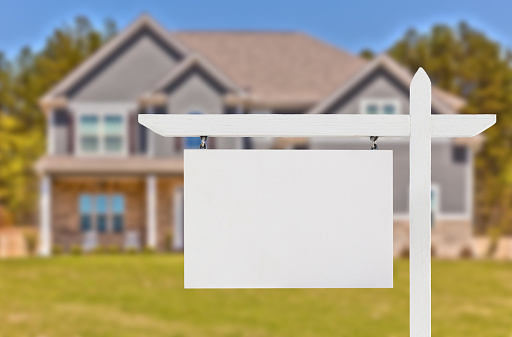 Blank Real Estate Sign in Front of Beautiful New House.