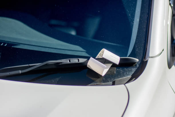 Ticket for illegal parking issued by australian parking ranger on a windscreen of a white car Ticket for illegal parking issued by australian parking ranger on a windscreen of a white car traffic fine stock pictures, royalty-free photos & images