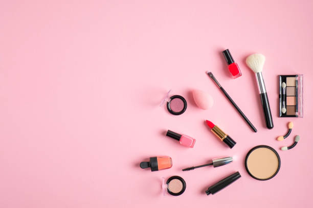 istock Professional makeup cosmetics set. Flat lay composition with lipstick, nail polish, make-up brush, nude eyeshadow palette on pastel pink background. Beauty salon banner design template 1205849853