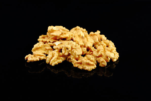 istock Walnuts with yellow autumn leaves isolated on black background 1205851659