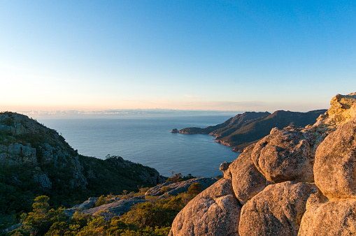 Epic mountain sunrise landscape with picturesque lagoon and large lava boulders. Sunrise at Mount Amos in Tasmania, Australlia