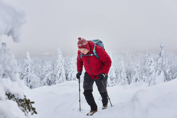 istock male traveler climbs a mountain during a snowfall 1205853388