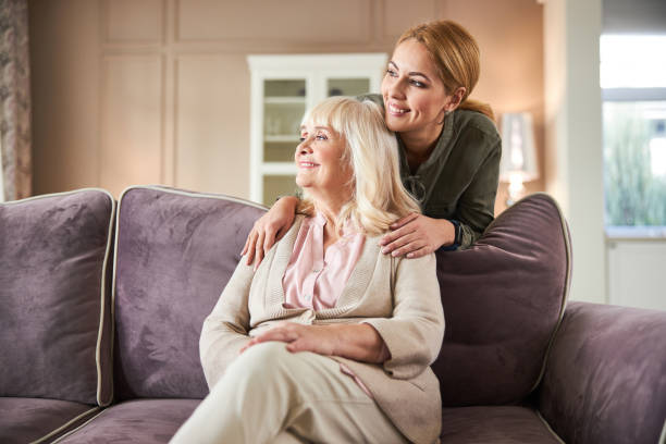 istock Smiling senior woman resting on sofa at home 1205854124