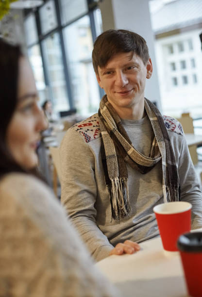 istock a smiling young man talking to a woman in a cafe 1205854364