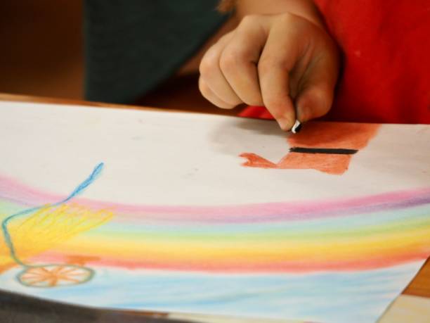 istock Young Child Using Chalk Pastels to Draw on Paper 1205862138
