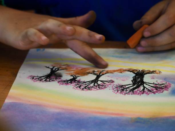 istock Young Child Using Chalk Pastels to Draw on Paper 1205862659