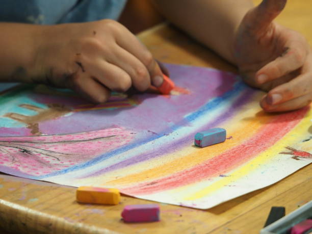 istock Young Child Using Chalk Pastels to Draw on Paper 1205862679