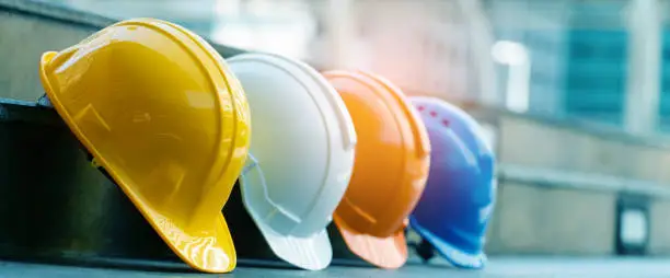 Photo of Safety Construction Worker Hats Blue, white, yellow, orange. Teamwork of construction team must have quality. Whether it engineer, construction workers. Have a helmet to wear at work. Safety at work.
