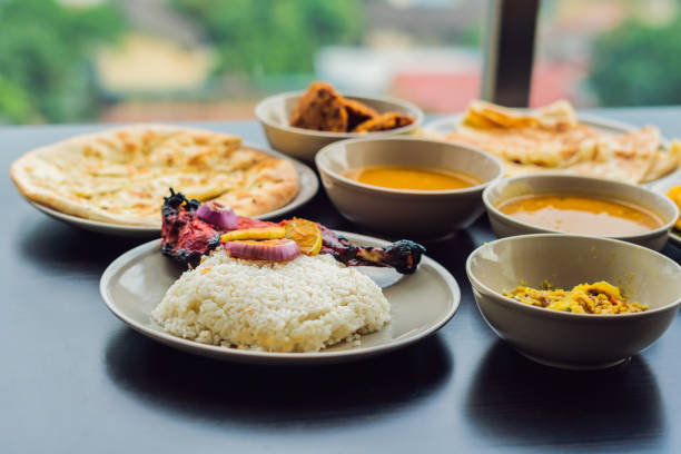 assorted indian food on dark wooden background. dishes and appetizers of indian cuisine. curry, butter chicken, rice, lentils, paneer, samosa, naan, chutney, spices. bowls and plates with indian food - 3675 imagens e fotografias de stock