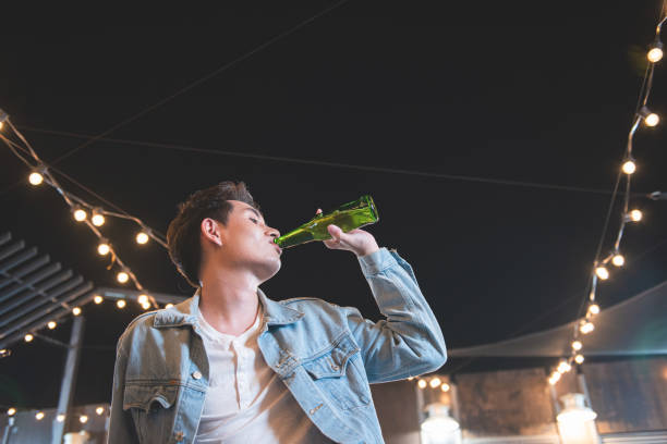 istock One young asian man drink bottle of beer. 1205866648