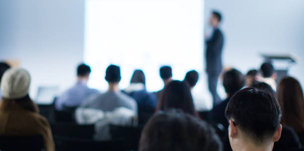istock Business man making a presentation at office. Business executive delivering a presentation to his colleagues during meeting or in-house workshop. Rear view. Business and entrepreneurship. 1205869216