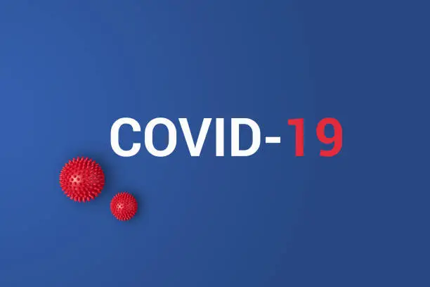 Photo of Iinscription COVID-19 on blue background with red ball