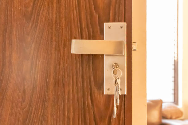 istock Door lock handle with set of keys hanging with door 1205875879