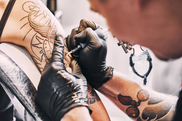 istock Tattoo Artist making a tattoo on a shoulder 1205881099