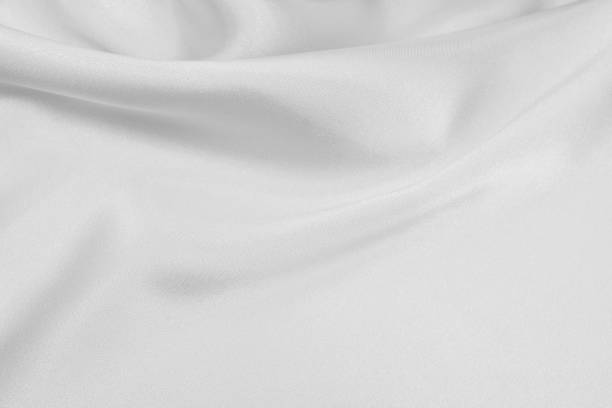 istock Delicate satin draped fabric white texture for festive backgrounds 1205887189
