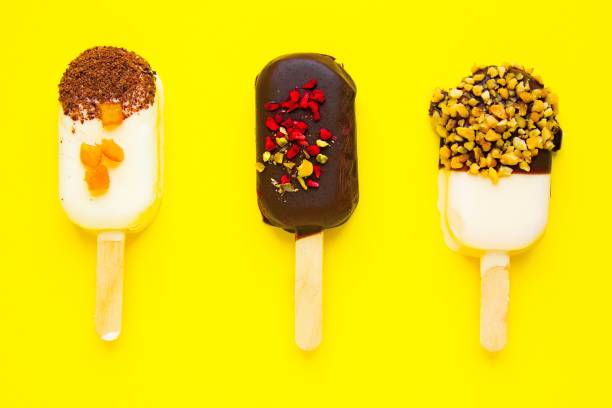 istock Sweet popsicles on yellow background. Mini dessert close up. 1205895066