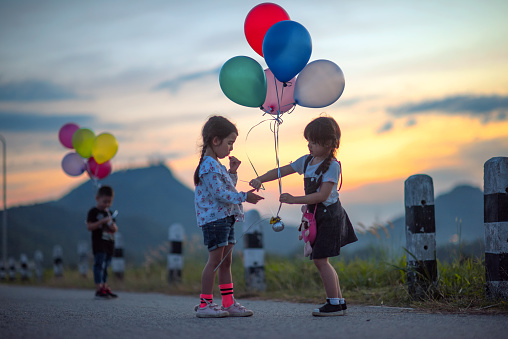 kids playing and sharing toys balloons together