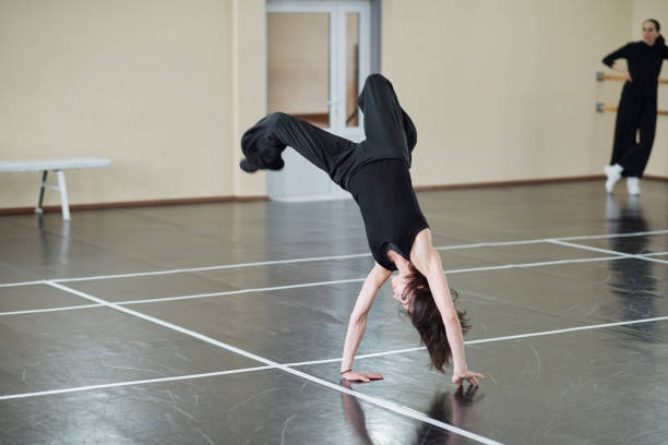 Dancer Doing Handspring Young female dancer wearing black outfit doing difficult handspring element, horizontal shot handspring stock pictures, royalty-free photos & images