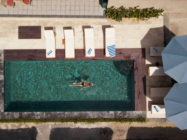 istock Woman swimming in pool, drone aerial view 1205903272