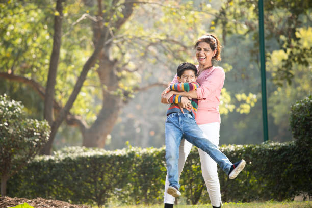 istock Happy mother playing with her son at park 1205903348