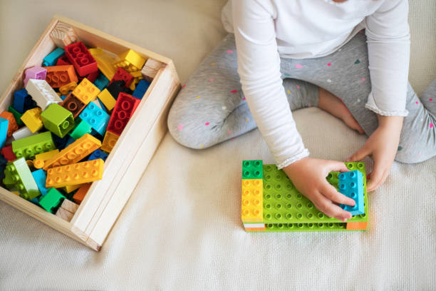 istock Little girl playing with her colorful blocks. 1205903738