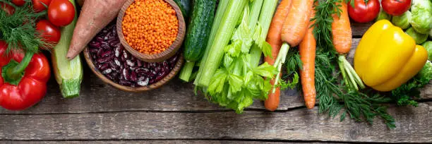 Background healthy eating. Fresh vegetables, fruits, beans and lentils on wooden table. Vegetarian food. Healthy food, diet and healthy eating concept. Top view, copy space